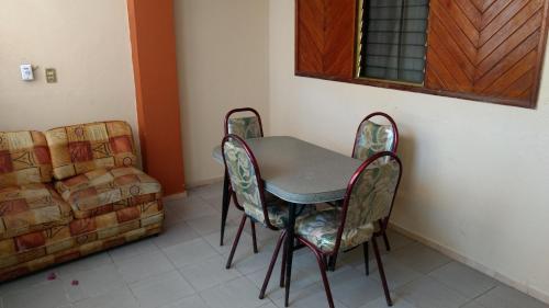 a table and chairs in a room with a couch at Hotel y Bungalows Olivares in Acapulco