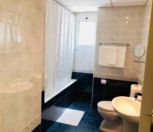 a bathroom with a toilet and a sink and a shower at Stylish Apartment with Spacious Terrace in Aglantzia