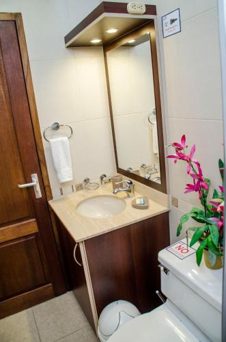 a bathroom with a sink and a toilet and a mirror at Family-Flexication-Friendly Villa, few steps from Eagle Beach in Palm-Eagle Beach