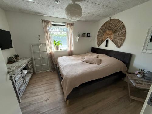 a bedroom with a large bed and a window at Hyggeligt hus. in Holstebro
