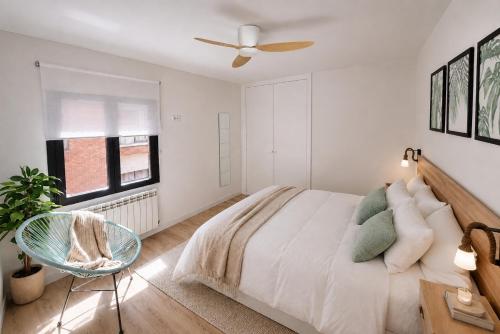 a white bedroom with a bed and a ceiling fan at Apartamento Premium Ávila PLAZA MAYOR con PARKING in Ávila