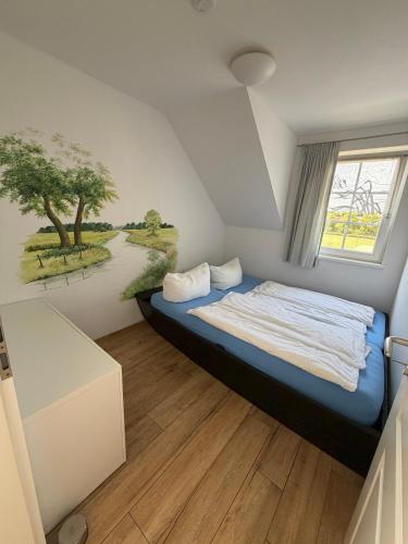 a bedroom with a bed with a painting on the wall at Ferienwohnung Hafen in Neuendorf am See