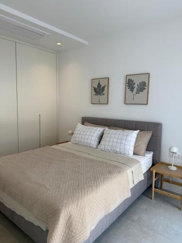 a bedroom with a large bed with white walls at Charming studio-plus in Lustica Bay Centrale in Radovici