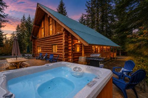 a hot tub in front of a log cabin at Soaring Pines Lodge by NW Comfy Cabins in Leavenworth