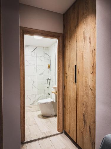 a bathroom with a white toilet and a shower at Lost At Sea 2 in Sarandë