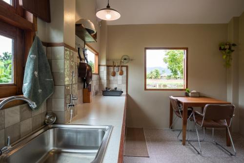 a kitchen with a sink and a table at The BROWN PAI in Pai