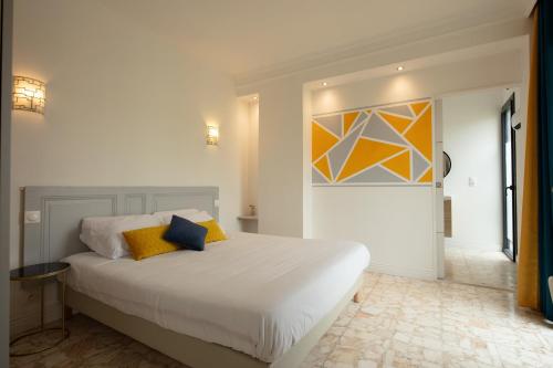 a bedroom with a bed and a painting on the wall at MAISON MIGNARDISE - Cité in Carcassonne