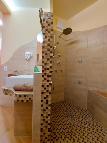 a bathroom with a shower and a sink and a tub at Rosenhotel - Serviced Apartments in Zwentendorf