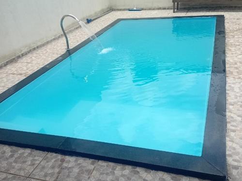 a large blue swimming pool with a water hose at Chácara silva in Nova Serrana