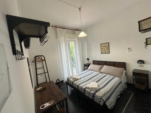 a bedroom with a bed and a table and a window at Hotel La Pineta in Cogoleto