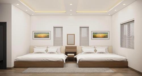 two beds in a room with white walls at Eco House Cat Ba in Hai Phong