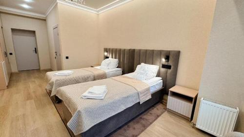 a hotel room with two beds with towels on them at Hotel Palace Ukraine in Mykolaiv