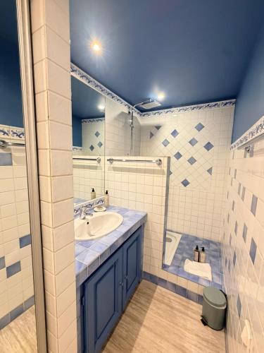 a blue and white bathroom with a sink and a shower at Lou Cagnard in Saint-Tropez