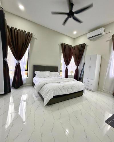 a bedroom with a bed and a ceiling fan at Aman Homestay, Marang in Marang