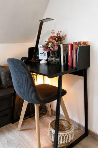 a desk with a chair next to a desk with a computer at Studio duplex à Savenay - Calme & tout confort entre Nantes & l'océan in Savenay