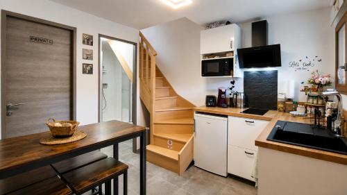 a small kitchen with a table and a staircase at Studio duplex à Savenay - Calme & tout confort entre Nantes & l'océan in Savenay