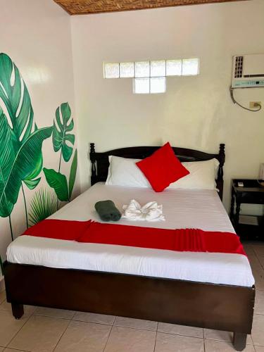 a bedroom with a bed with red and white pillows at Azure Camotes Resort Hotel in Camotes Islands