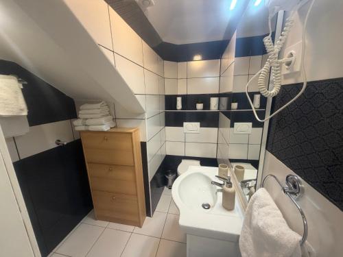 a small bathroom with a sink and a toilet at Guest House Kvartin in Umag