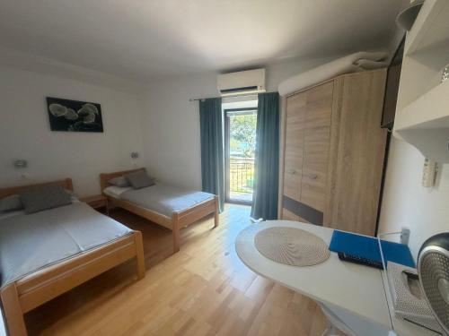 a small room with two beds and a table at Guest House Kvartin in Umag