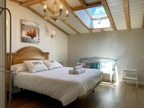 a bedroom with a large white bed with a window at Casa Rural el Cedro in Abejar