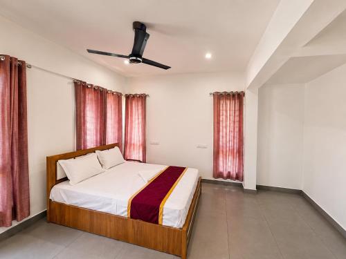 a bedroom with a bed and a ceiling fan at Zenora Suites in Kozhikode