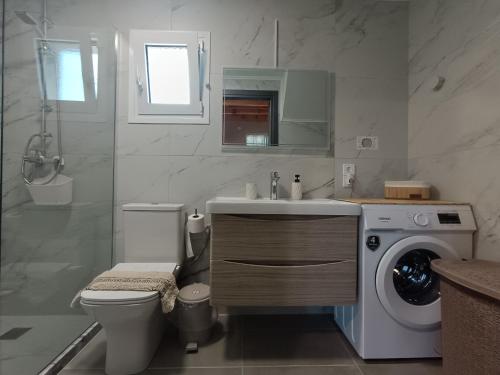 a bathroom with a sink and a washing machine at River Houses Molyvos in Mythimna