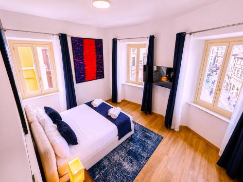 a bedroom with a bed and two windows at Baglioni Art Suite in Perugia