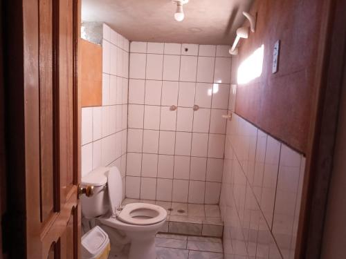 a small bathroom with a toilet and a shower at Hospedaje jatari in Estanciasuyo