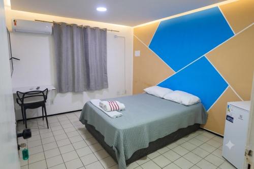 a room with a bed with a blue accent wall at Hostel Way Fortaleza in Fortaleza
