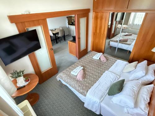 a room with two beds and a flat screen tv at BeWell Apartment in Zalakaros