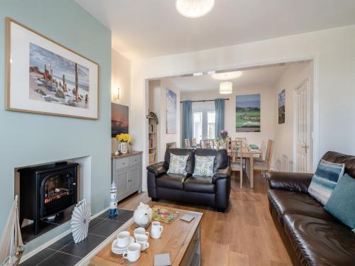 a living room with a couch and a fireplace at Samphire in Bacton