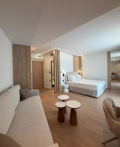 a hotel room with a bed and a couch and tables at Local Urban Living in Volos