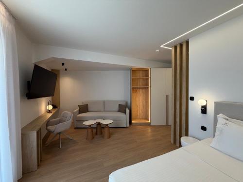 a room with a bed and a couch and a tv at Local Urban Living in Volos