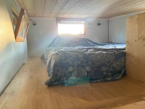 a bed in a small room with a window at Tiny ou Petite maison sur roulettes in Le Fay