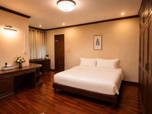 a bedroom with a bed and a desk and a bed sidx sidx sidx at Kat's GuestHouse in Hua Hin