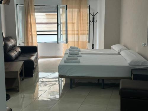a bed in a living room with a couch at Hostal Alegria Alicante in Alicante
