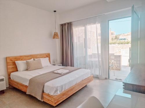 a bedroom with a bed and a large window at My Place modern living in Kefalos