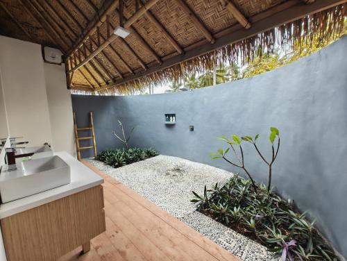 a bathroom with a sink and a concrete wall at Sumba Retreat Kerewe in Waikabubak