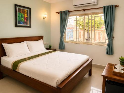 a bedroom with a bed and a window at Abode Hotel Siem Reap in Phum Pobos