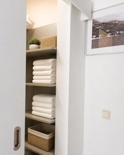 a closet with white towels on a shelf at Villa Jurisic in Tučepi