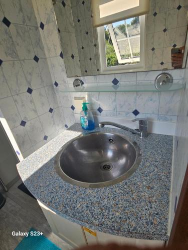 a sink in a small bathroom with a window at De Weerribben Wieden, Natuurhuisje in Wanneperveen