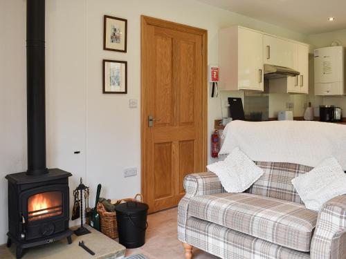 a living room with a couch and a stove at Brooklands Cottage in Bellerby