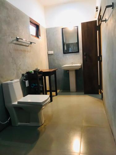 a bathroom with a toilet and a sink at Villa Habarana in Habarana