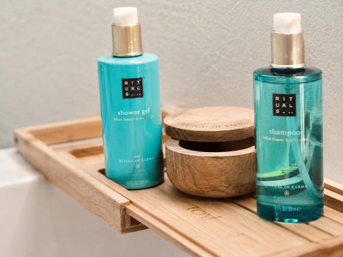 two bottles of soap sitting on a wooden tray at Hotel PI Arte Exclusive Suite in Palermo