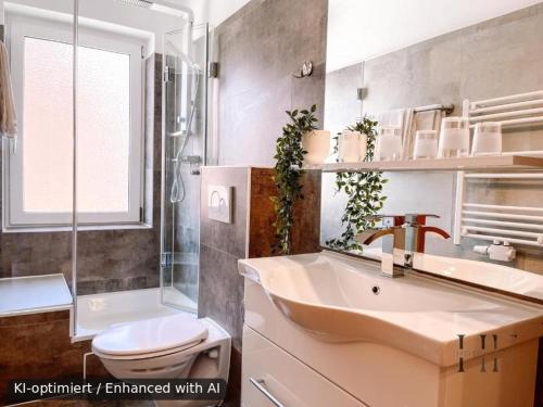 a bathroom with a sink and a toilet and a shower at Hotel Falk in Bremen