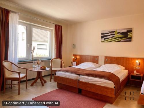 a bedroom with a bed and a table with chairs at Hotel Falk in Bremen