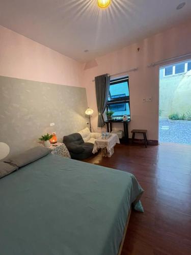a bedroom with a bed and a living room at BalaHomestay BalaHouse in Lạc Thành