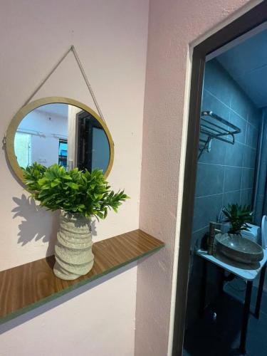 a mirror and a vase on a shelf in a bathroom at BalaHomestay BalaHouse in Lạc Thành