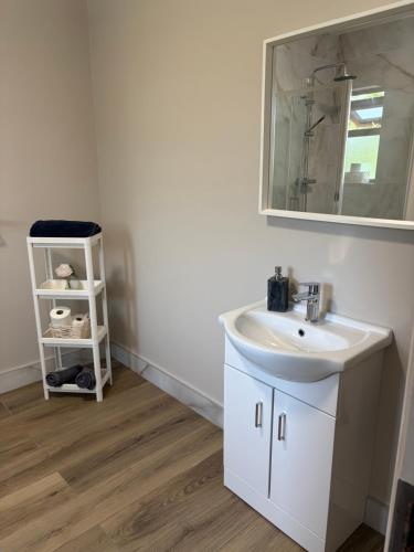 a bathroom with a sink and a mirror at Cosy apartment - Na Creagáin in Tully