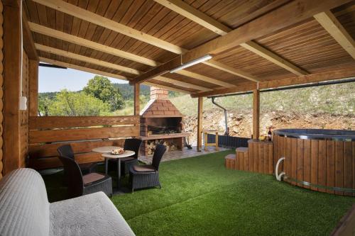 an outdoor patio with a fireplace and green grass at Villa Velebita House for 9 near Plitvice Lakes in Rudopolje
